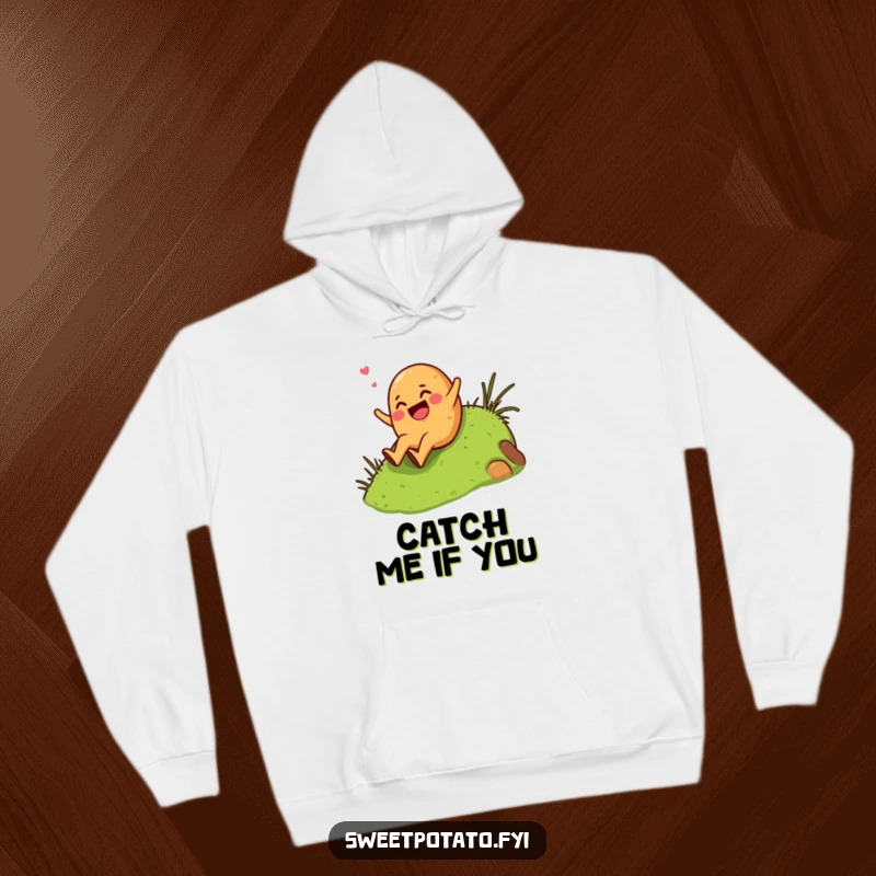 Funny giggling sweet potato character enthusiastically sliding down a grassy hill, featured on a cozy and humorous hoodie.