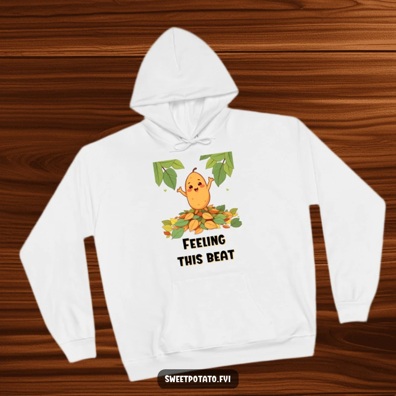 Funny cheerful sweet potato character happily dancing on a pile of leaves, featured on a cozy and humorous hoodie.